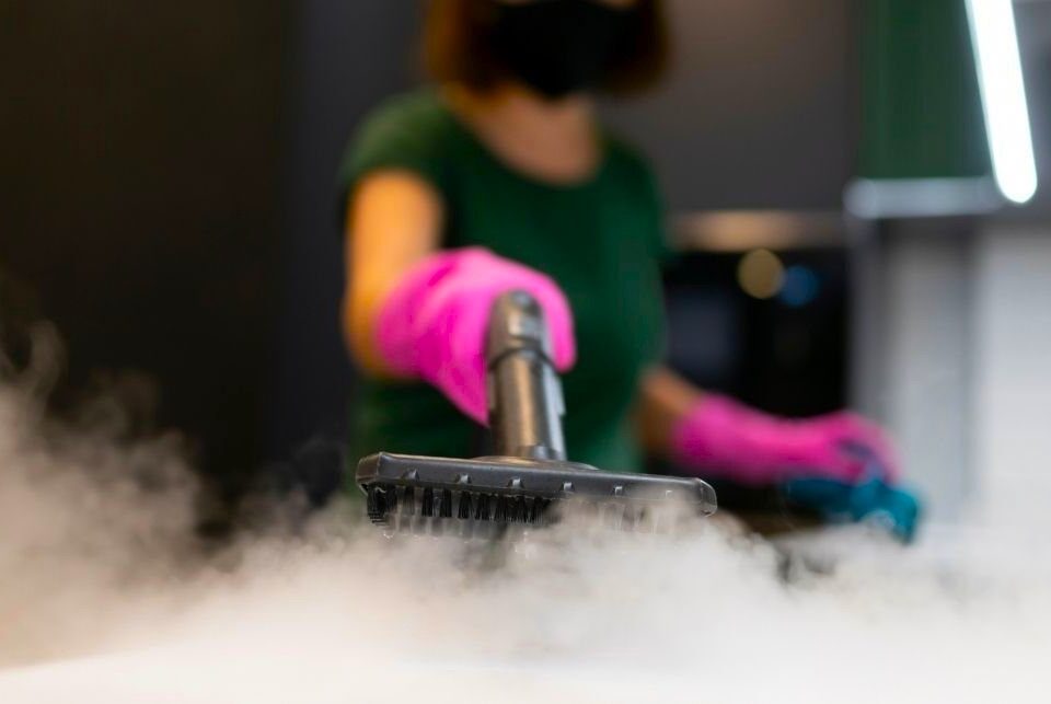 A woman steam cleaning sofa in Dubai